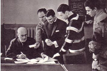 Фотокорреспондент Ю. Зенкович побывал в Государственном институте театрального искусства им. А. В. Луначарского, когда там впервые проходили экзамены на курсе режиссеров цирка. На снимке: студенты-заочники, артисты цирка (слева направо): М. Иванов, И. Бойков, В. Ярославцев, А. Арнаутов получают экзаменационные билеты у преподавателя по основам марксизма-ленинизма Б. Эренфельда. На созданном в начале нынешнего учебного года курсе режиссеров манежа учится двадцать артистов, в том числе В. Суркова, Л. Ермолаева, И. Кио, В. Анохин, В. Аверьянов и другие.